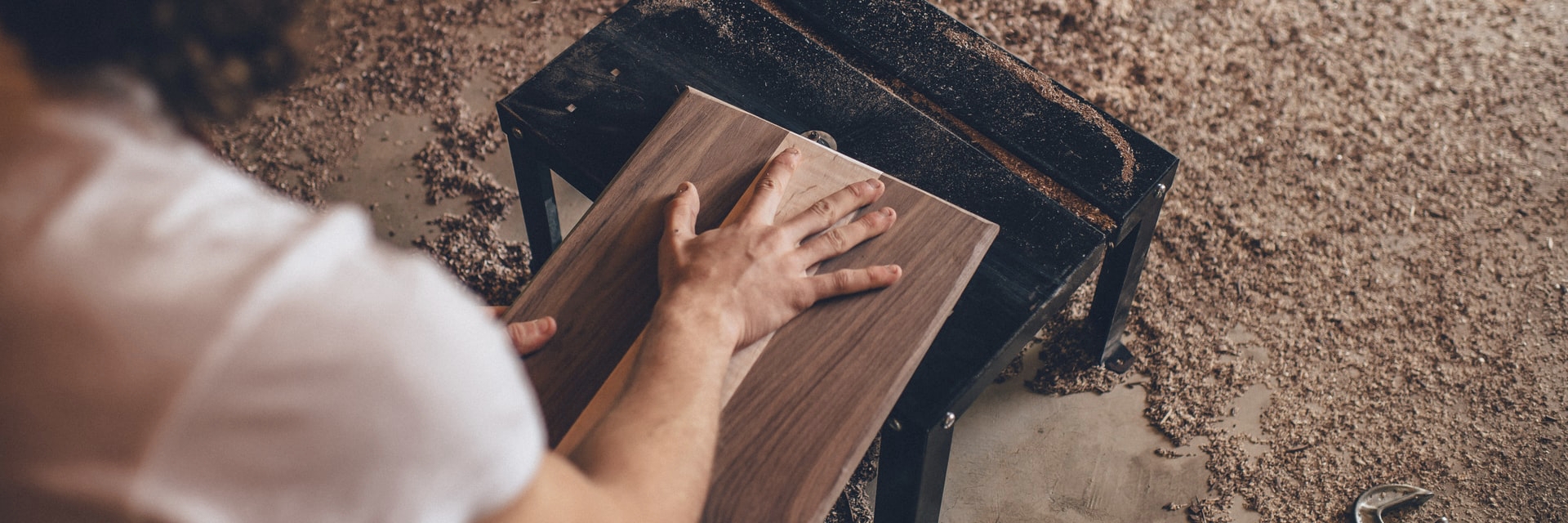 A person handling a piece of wood.