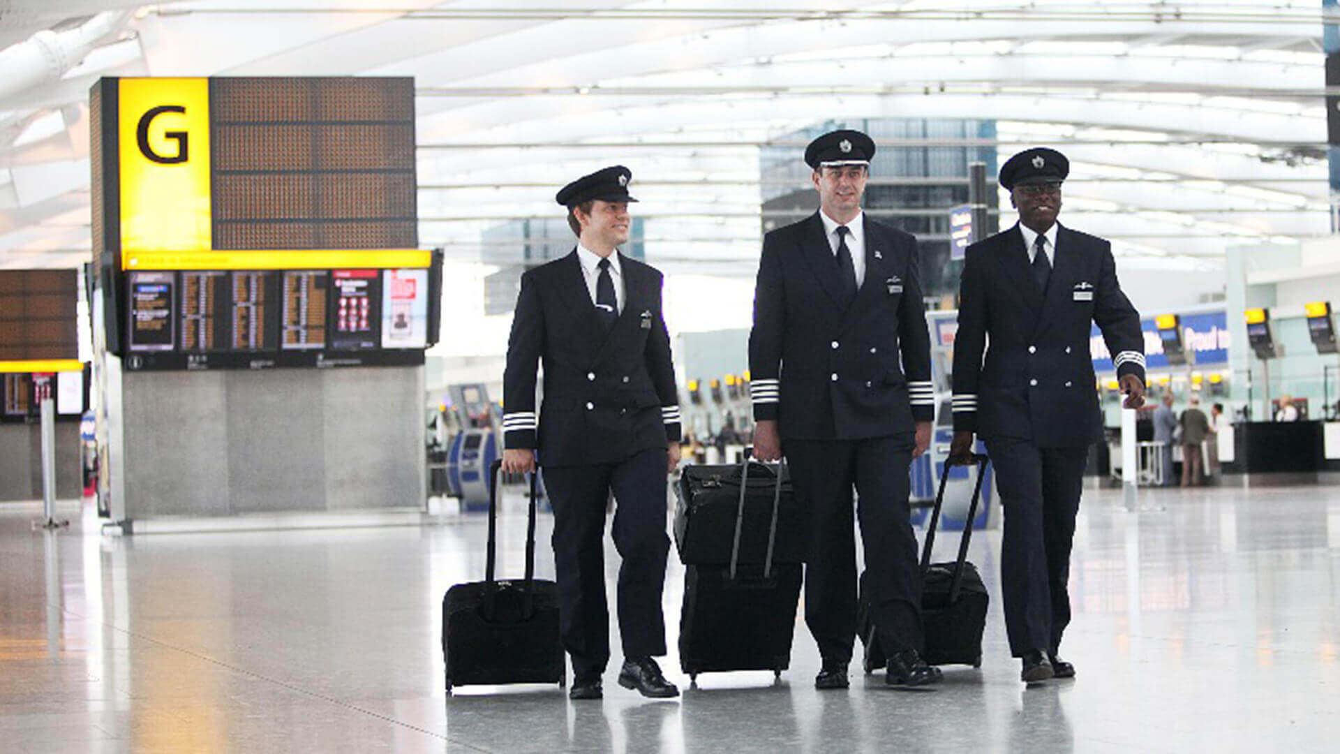 A flight crew walking inside an airport.